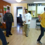 Photo: four adults dancing in a room with wood floors